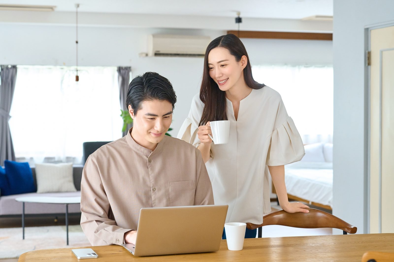 資料とパソコンを見ながら話し合うご夫婦